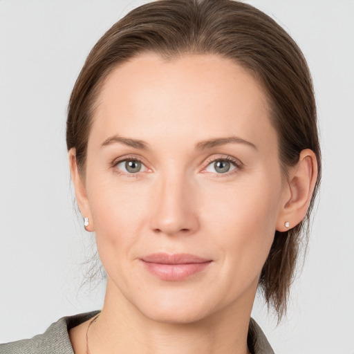 Joyful white young-adult female with medium  brown hair and grey eyes