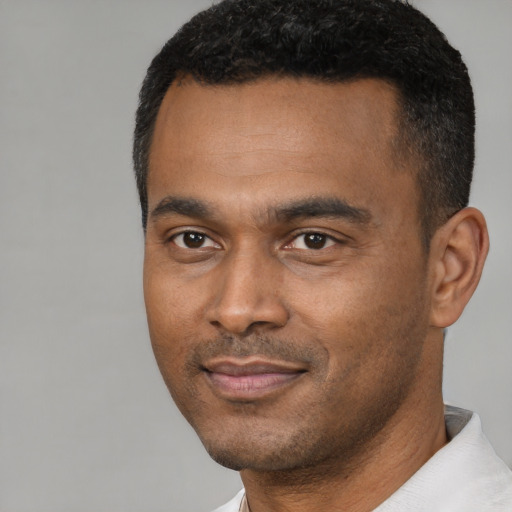 Joyful black young-adult male with short  black hair and brown eyes