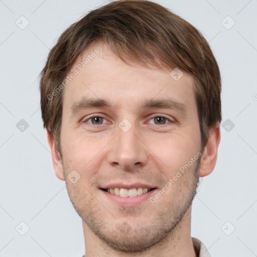 Joyful white young-adult male with short  brown hair and grey eyes