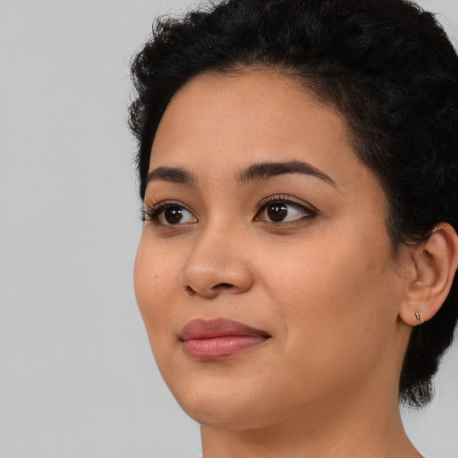 Joyful latino young-adult female with medium  black hair and brown eyes