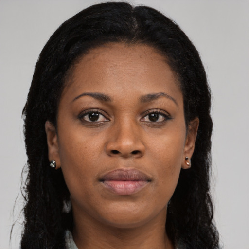 Joyful black young-adult female with long  brown hair and brown eyes