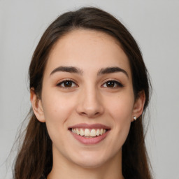 Joyful white young-adult female with long  brown hair and brown eyes