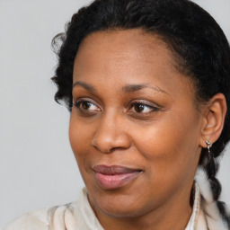 Joyful black adult female with medium  brown hair and brown eyes