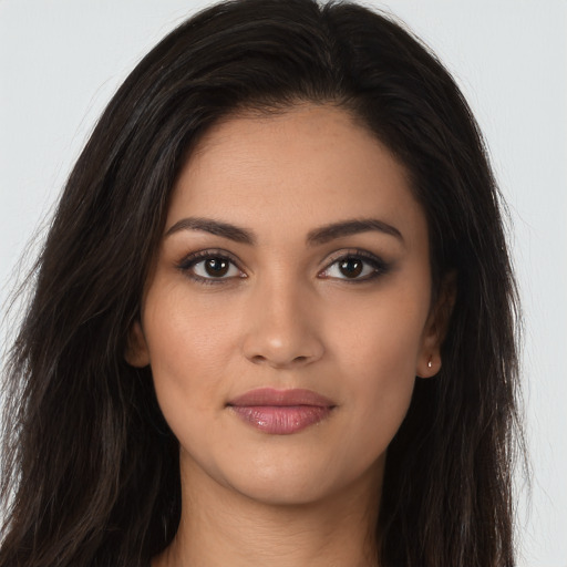 Joyful latino young-adult female with long  brown hair and brown eyes
