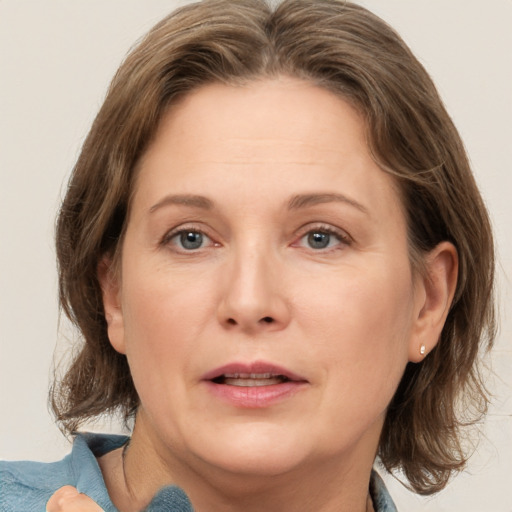 Joyful white adult female with medium  brown hair and grey eyes