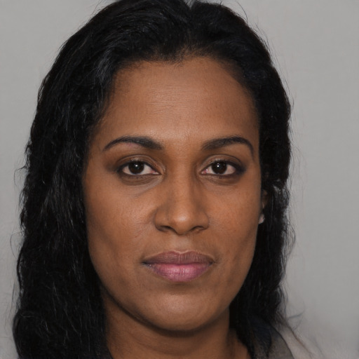 Joyful black young-adult female with long  brown hair and brown eyes