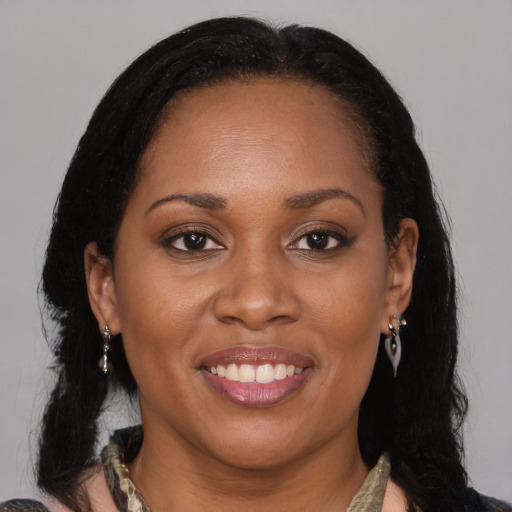 Joyful black adult female with medium  brown hair and brown eyes