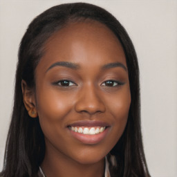 Joyful black young-adult female with long  brown hair and brown eyes