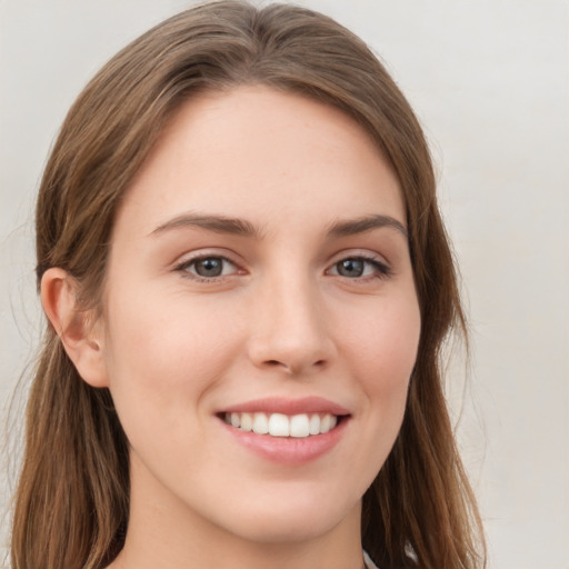 Joyful white young-adult female with long  brown hair and grey eyes