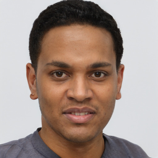 Joyful black young-adult male with short  black hair and brown eyes