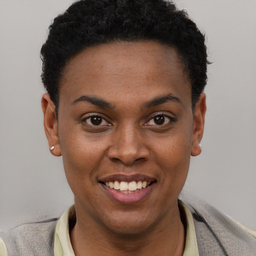 Joyful black young-adult female with short  black hair and brown eyes