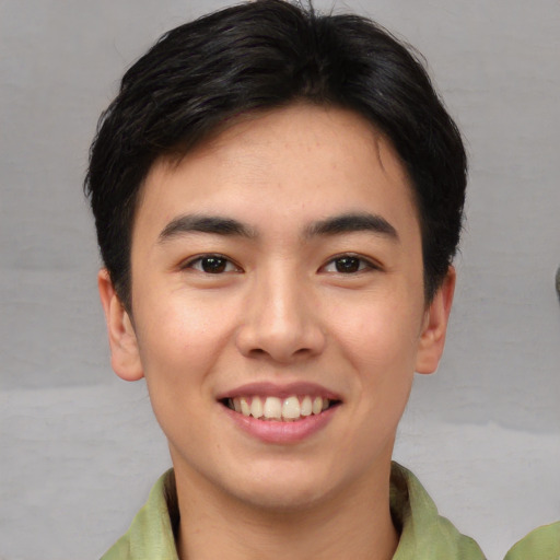 Joyful asian young-adult male with short  brown hair and brown eyes