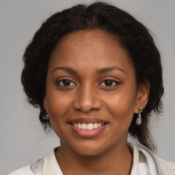 Joyful black adult female with medium  brown hair and brown eyes