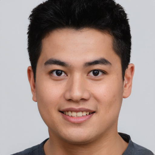 Joyful asian young-adult male with short  brown hair and brown eyes