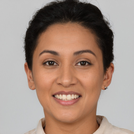 Joyful latino young-adult female with short  brown hair and brown eyes
