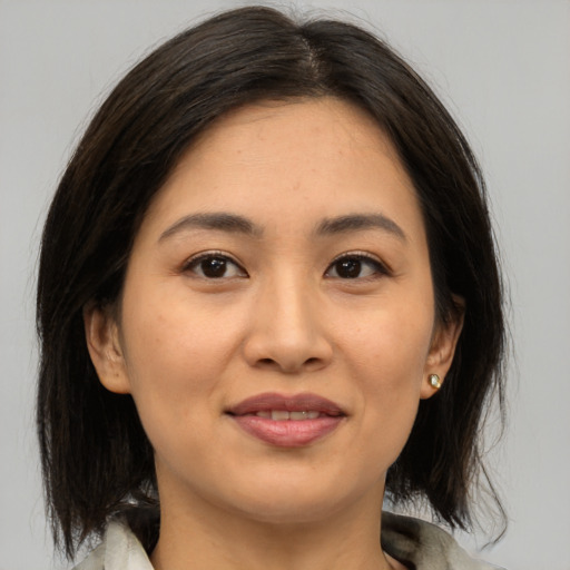 Joyful asian young-adult female with medium  brown hair and brown eyes