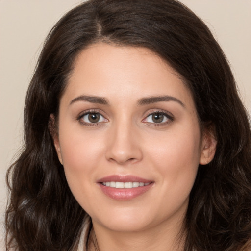 Joyful white young-adult female with long  brown hair and brown eyes