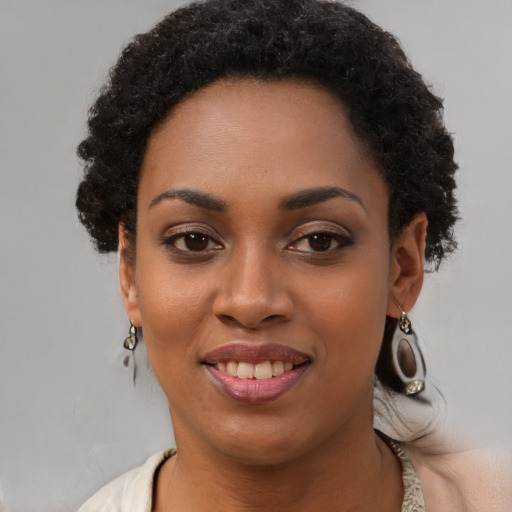 Joyful black young-adult female with short  black hair and brown eyes