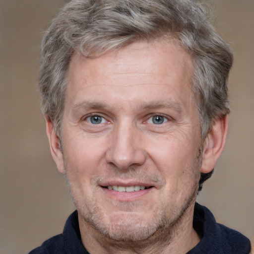 Joyful white middle-aged male with short  brown hair and grey eyes