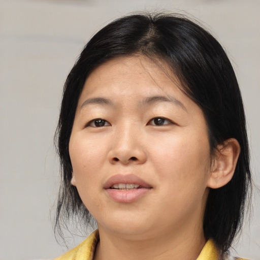 Joyful asian young-adult female with medium  brown hair and brown eyes