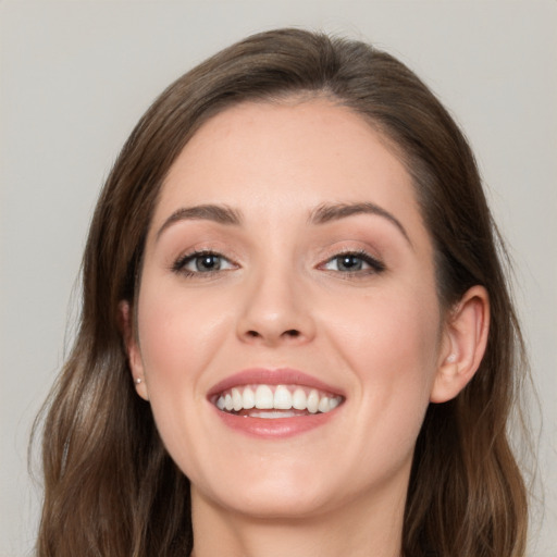 Joyful white young-adult female with long  brown hair and grey eyes