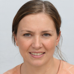 Joyful white young-adult female with medium  brown hair and grey eyes