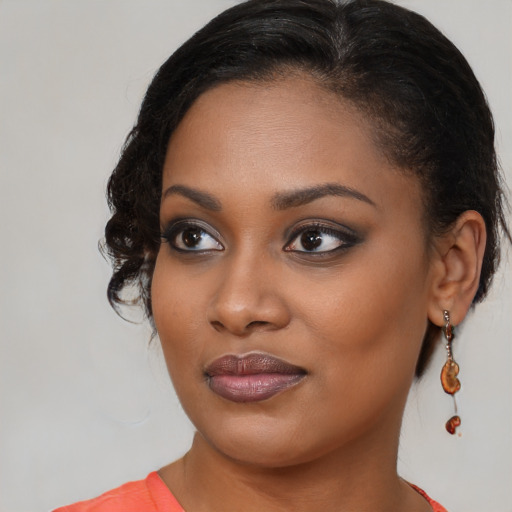 Joyful black young-adult female with medium  brown hair and brown eyes