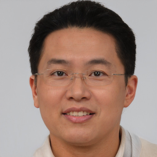 Joyful asian adult male with short  brown hair and brown eyes