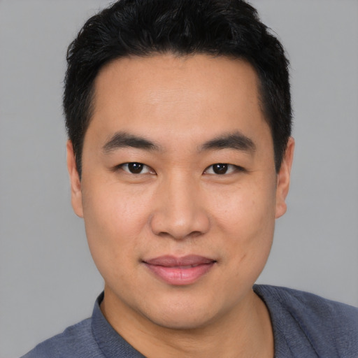 Joyful asian young-adult male with short  black hair and brown eyes