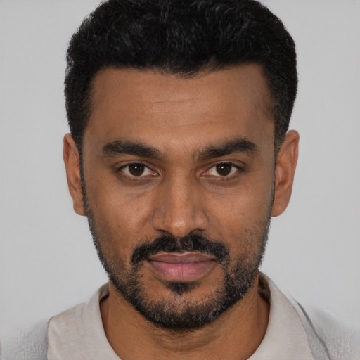 Joyful black young-adult male with short  black hair and brown eyes