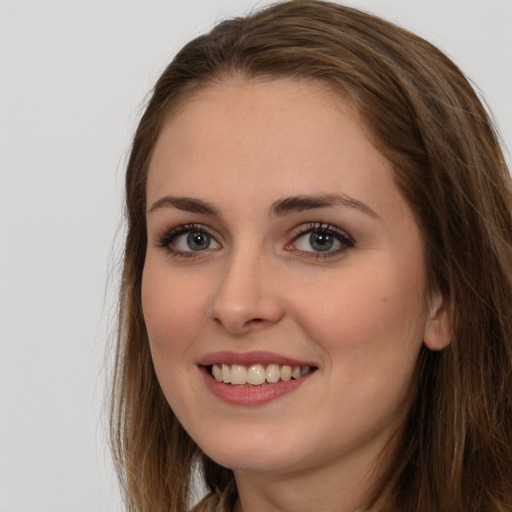 Joyful white young-adult female with long  brown hair and grey eyes