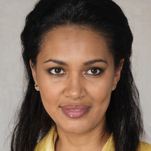 Joyful black young-adult female with long  brown hair and brown eyes