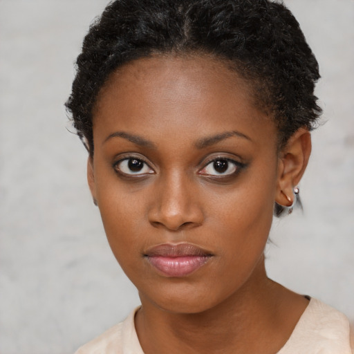 Joyful black young-adult female with short  brown hair and brown eyes