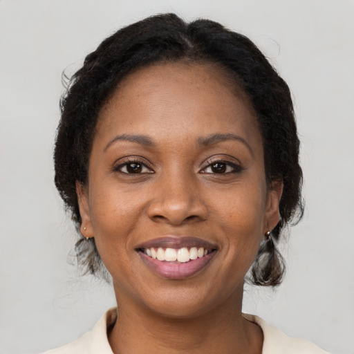 Joyful black young-adult female with medium  brown hair and brown eyes