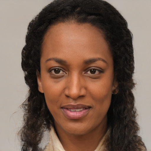 Joyful black young-adult female with long  brown hair and brown eyes