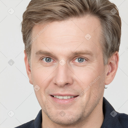 Joyful white adult male with short  brown hair and grey eyes