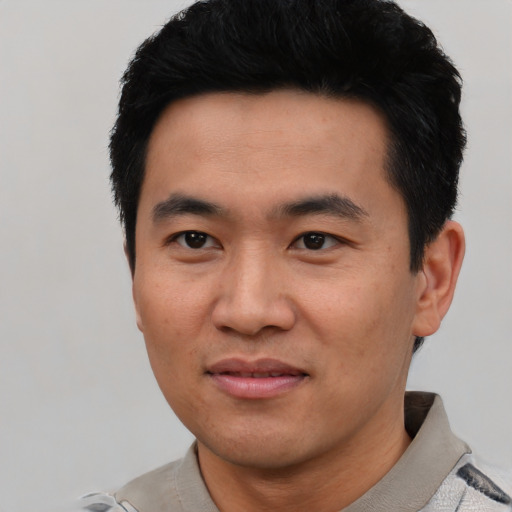 Joyful asian young-adult male with short  black hair and brown eyes