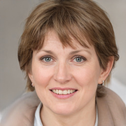 Joyful white adult female with medium  brown hair and grey eyes