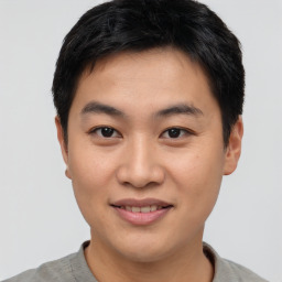 Joyful asian young-adult male with short  black hair and brown eyes