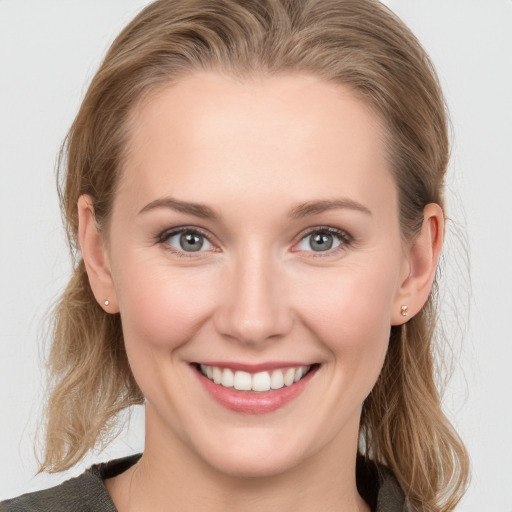 Joyful white young-adult female with medium  brown hair and grey eyes