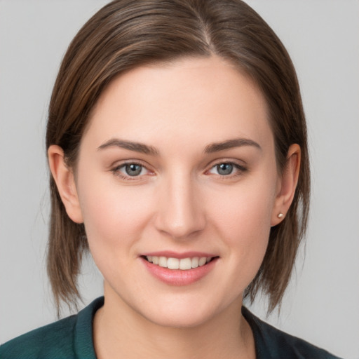 Joyful white young-adult female with medium  brown hair and grey eyes