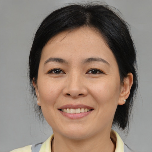 Joyful asian adult female with medium  brown hair and brown eyes