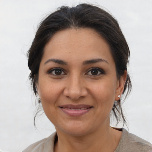 Joyful latino adult female with medium  brown hair and brown eyes