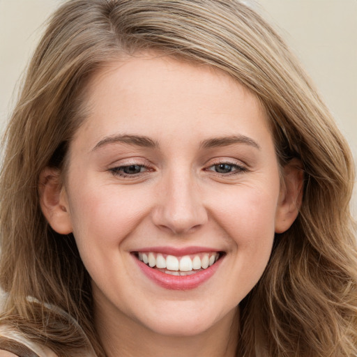 Joyful white young-adult female with long  brown hair and blue eyes