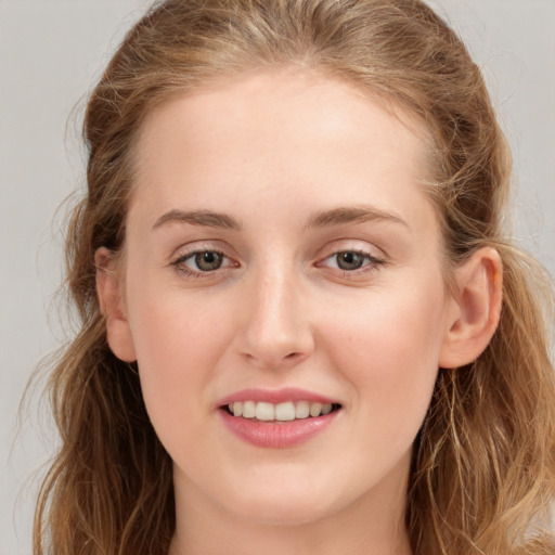 Joyful white young-adult female with long  brown hair and grey eyes