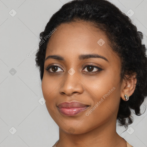 Joyful black young-adult female with long  black hair and brown eyes