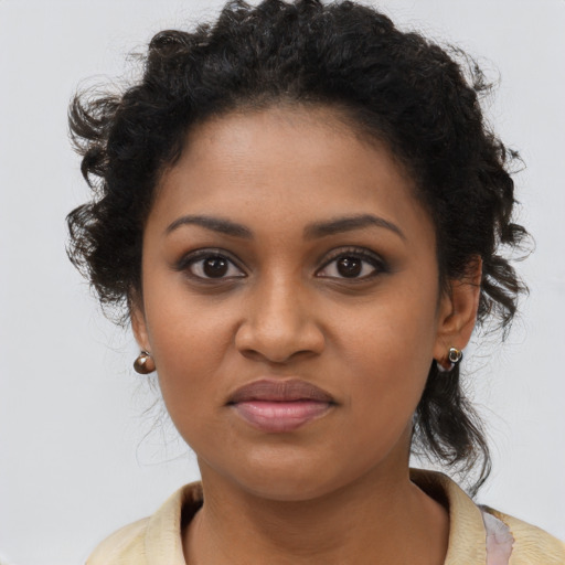 Joyful black young-adult female with long  brown hair and brown eyes