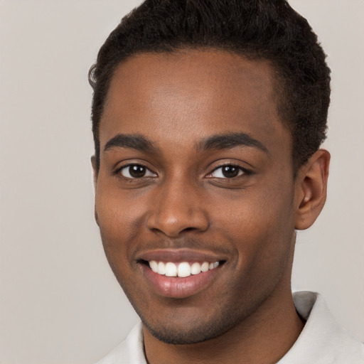 Joyful black young-adult male with short  brown hair and brown eyes