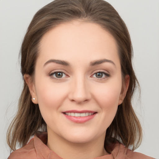 Joyful white young-adult female with medium  brown hair and grey eyes