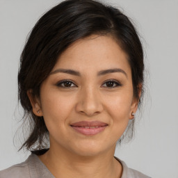 Joyful latino young-adult female with medium  brown hair and brown eyes